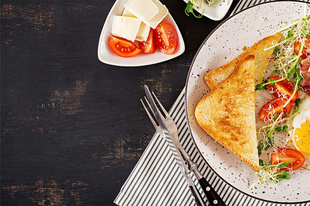 Brunch-Teller auf schwarzem Tisch mit frischen Zutaten