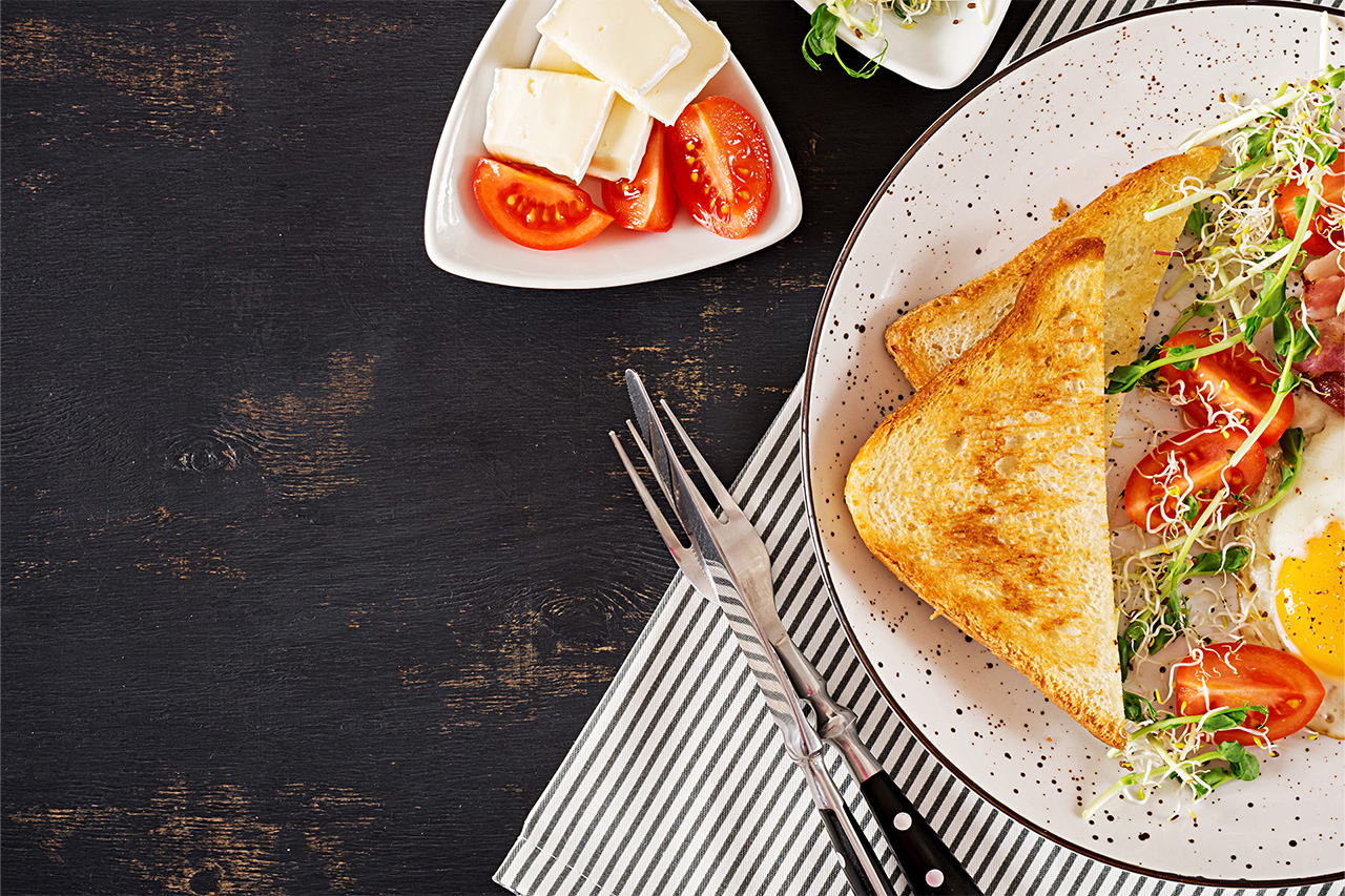 Brunch-Teller auf schwarzem Tisch mit frischen Zutaten